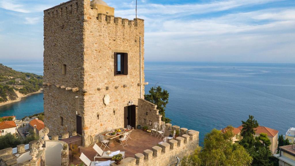 um velho castelo com o oceano atrás dele em TORRE GRIMALDI 2&2, Emma Villas em Ventimiglia
