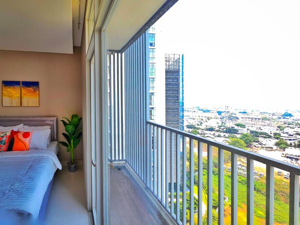 una camera da letto con balcone, letto e ampia finestra di Ciputra International Superblock Puri Kembangan a Giacarta