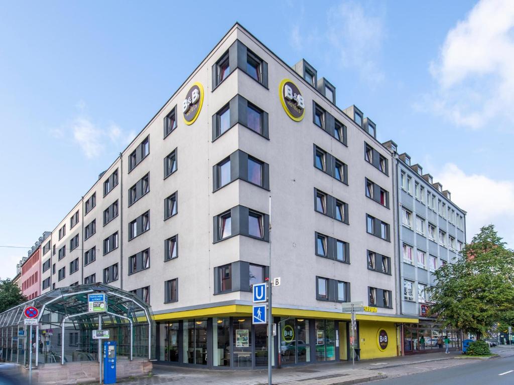 - un grand bâtiment blanc dans une rue de la ville dans l'établissement B&B Hotel Nürnberg-City, à Nuremberg