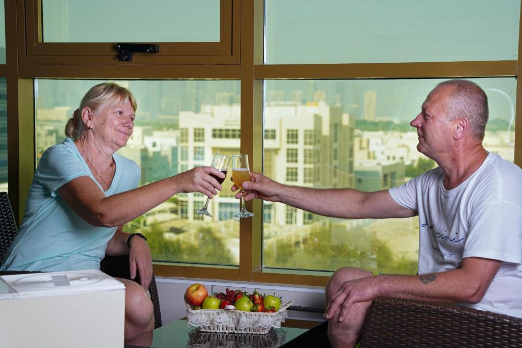 a man and a woman holding glasses of champagne at AG Hotel in Abu Dhabi
