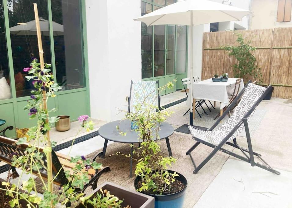 a patio with a table and chairs and an umbrella at Loft Saint-Jean in Monségur