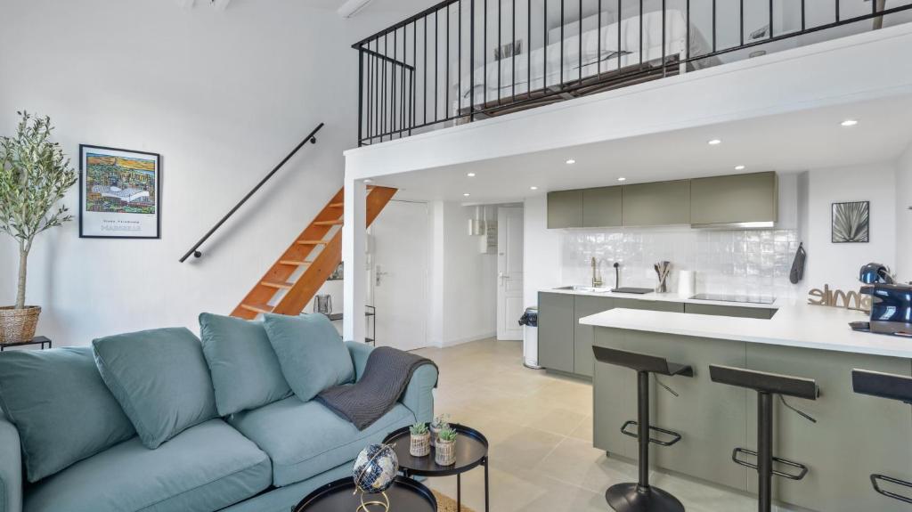 un salon avec un canapé bleu et une cuisine dans l'établissement Charmant logement au coeur du cours julien, à Marseille