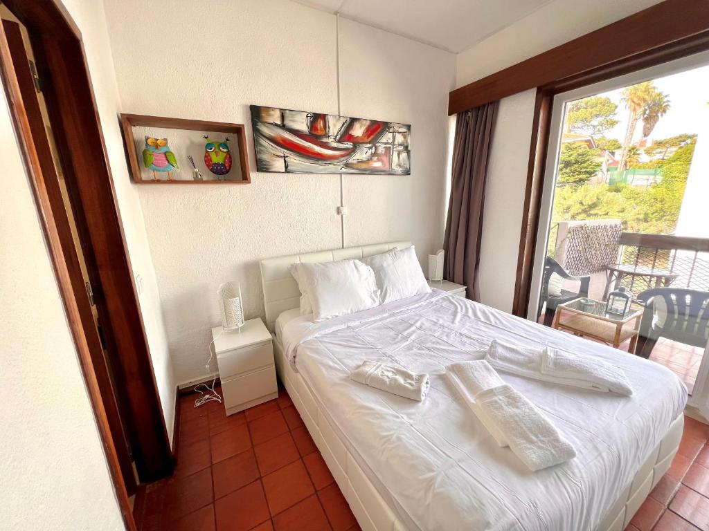 een slaapkamer met een wit bed en een balkon bij Nice & Cozy Little Studio with Terrace in Estoril in Estoril