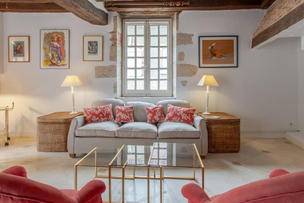 uma sala de estar com um sofá e uma mesa em La Reverdie Escapade aux pays des châteaux em Cellettes