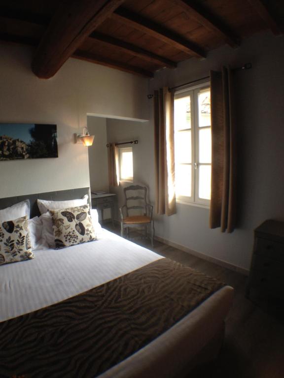 a bedroom with a bed and a window at Logis Hotel Restaurant la Ferme in Avignon