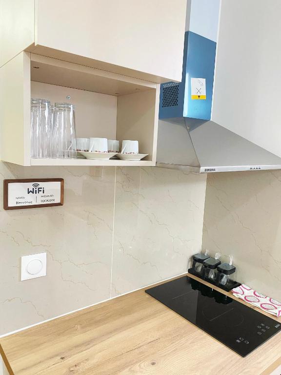 a kitchen with a cupboard with dishes on it at Chez les deux garçons in Montrouge