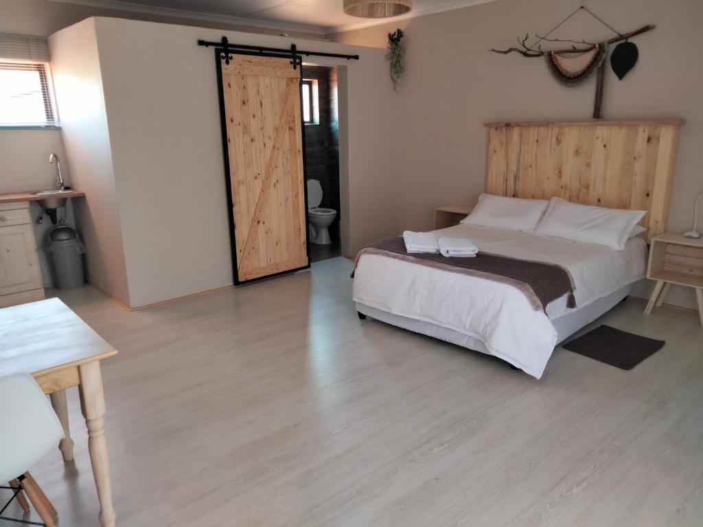 um quarto com uma cama e uma porta de correr em Rustic Stone Lodge em Thabazimbi