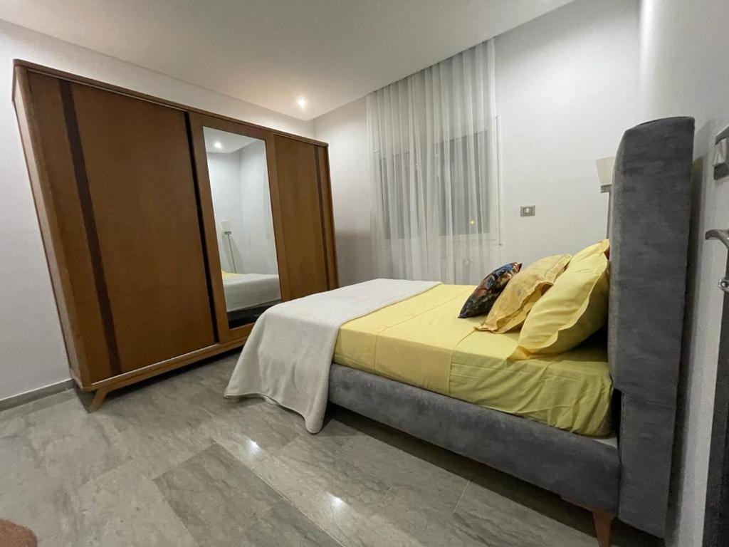 een slaapkamer met een bed en een grote spiegel bij Appartement l'aouina in El Aouina
