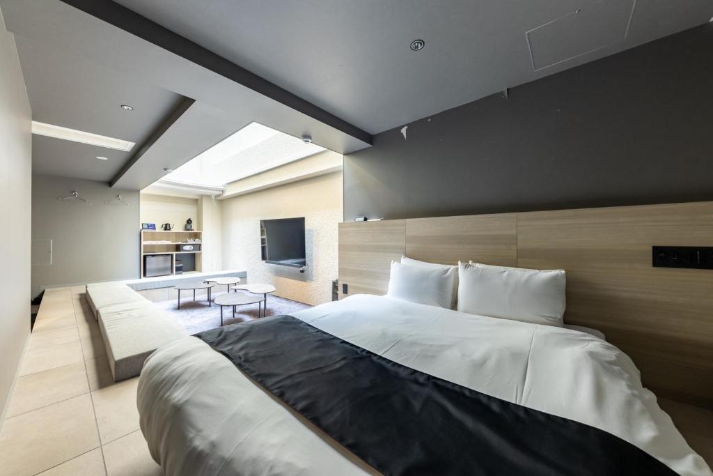 a bedroom with a large bed and a living room at 2269AZAVU in Tokyo