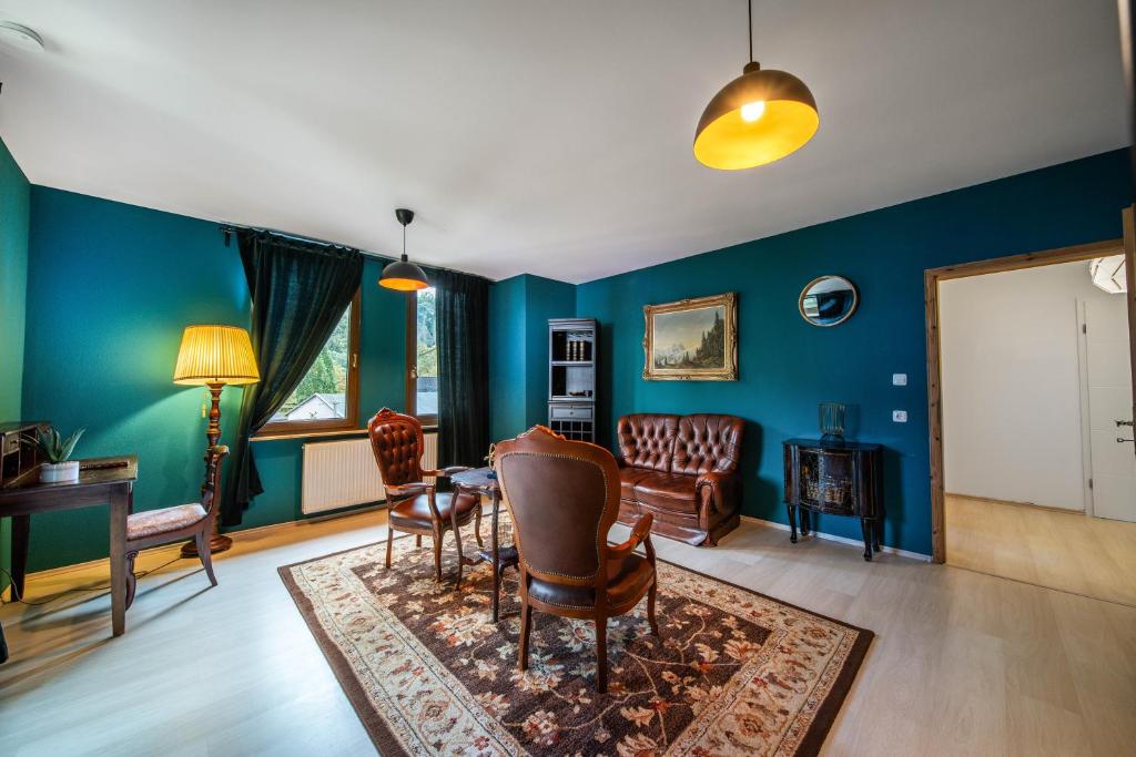 un soggiorno con pareti blu e tavolo e sedie di Bismarck Apt mit schönem Balkon und Herrenzimmer a Bad Ems