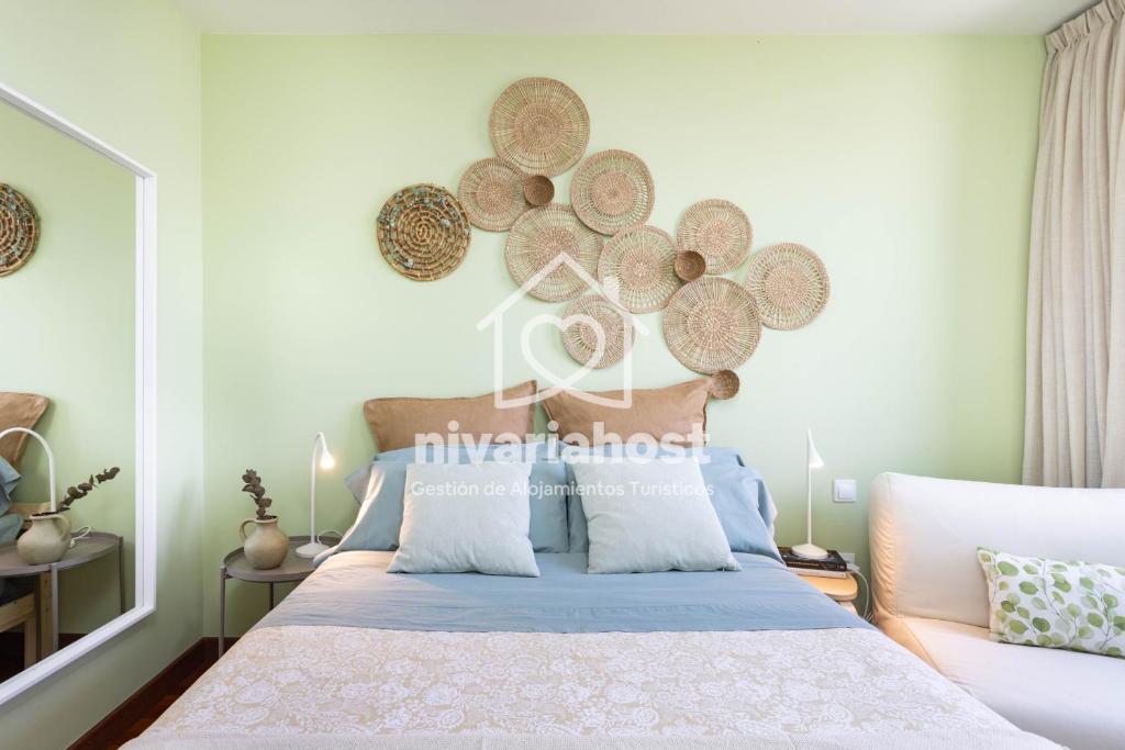 ein Schlafzimmer mit einem Bett mit Platten an der Wand in der Unterkunft The Mint Santa Cruz, by Nivariahost in Santa Cruz de Tenerife