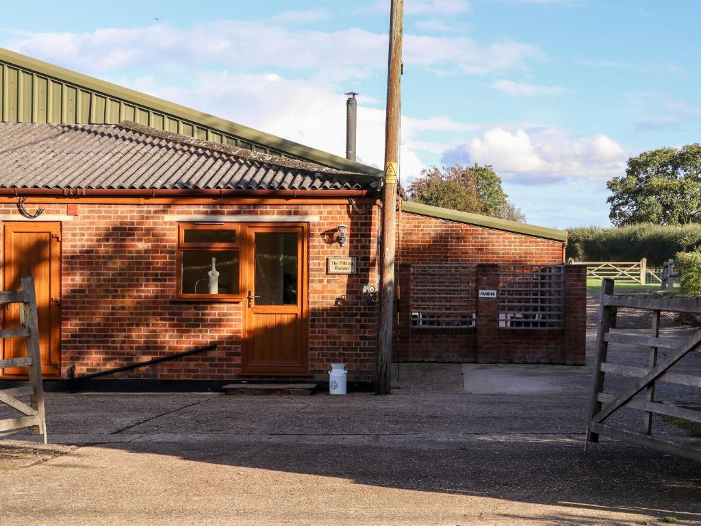 a brick building with a door and a window at The Milking Parlour in Cranbrook