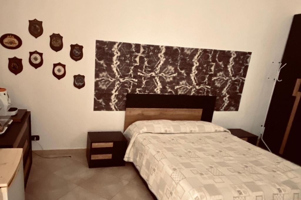 1 dormitorio con 1 cama y una pintura en la pared en Stupor Mundi, en Bitritto