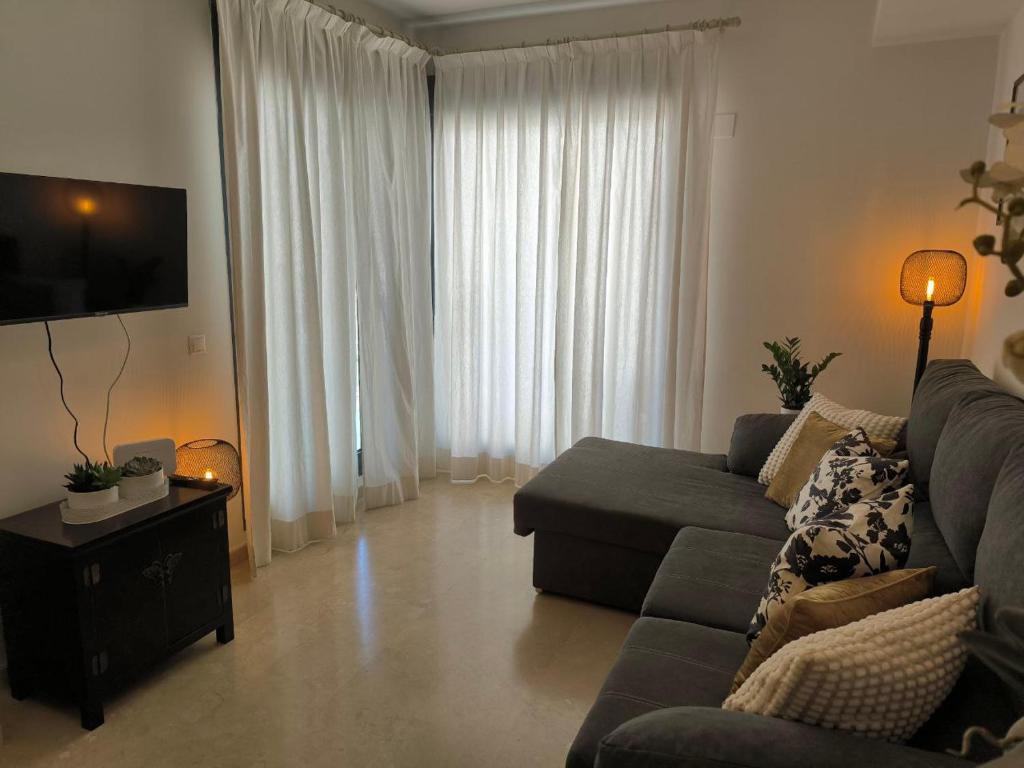 Una sala de estar con un sofá y un televisor. en Balay Apartment Benidorm, en Benidorm