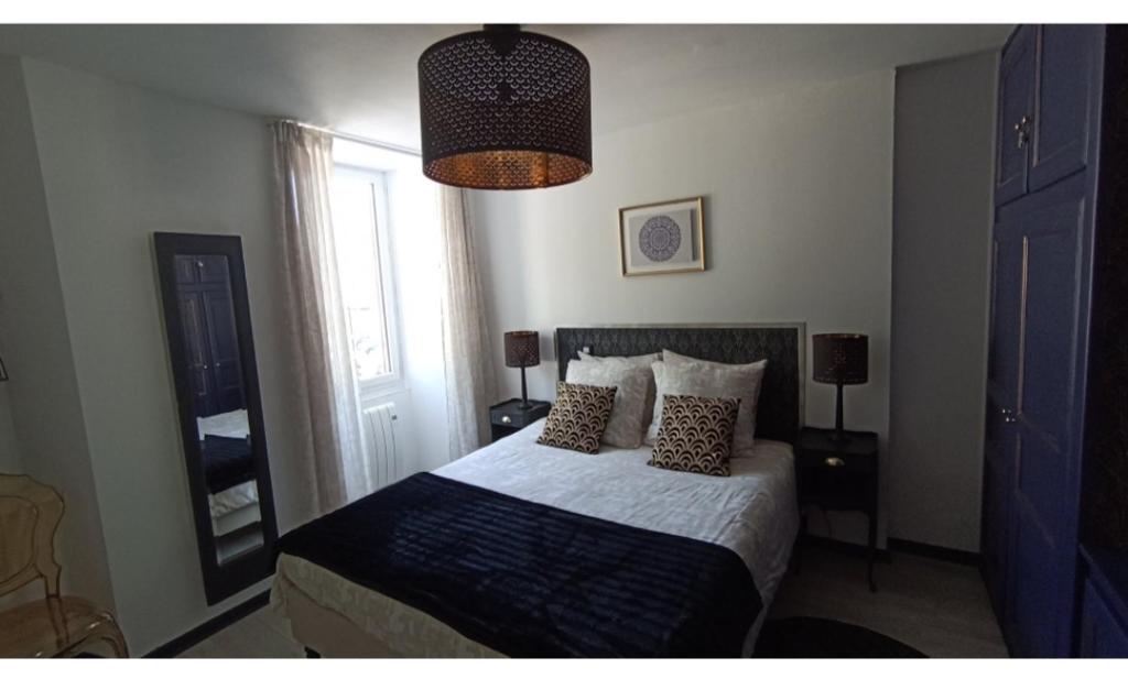 een slaapkamer met een bed met kussens en een raam bij L'Étape du Tourmalet in Luz-Saint-Sauveur