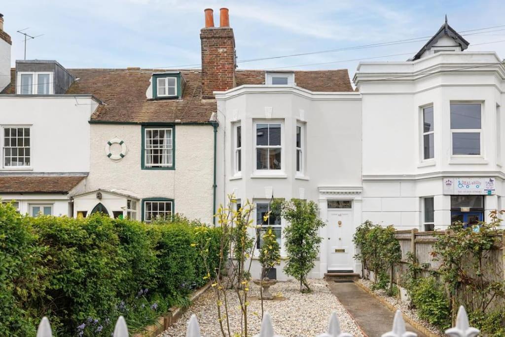 an exterior view of a white house at Pilots Lodge by Deal Castle with free parking in Deal