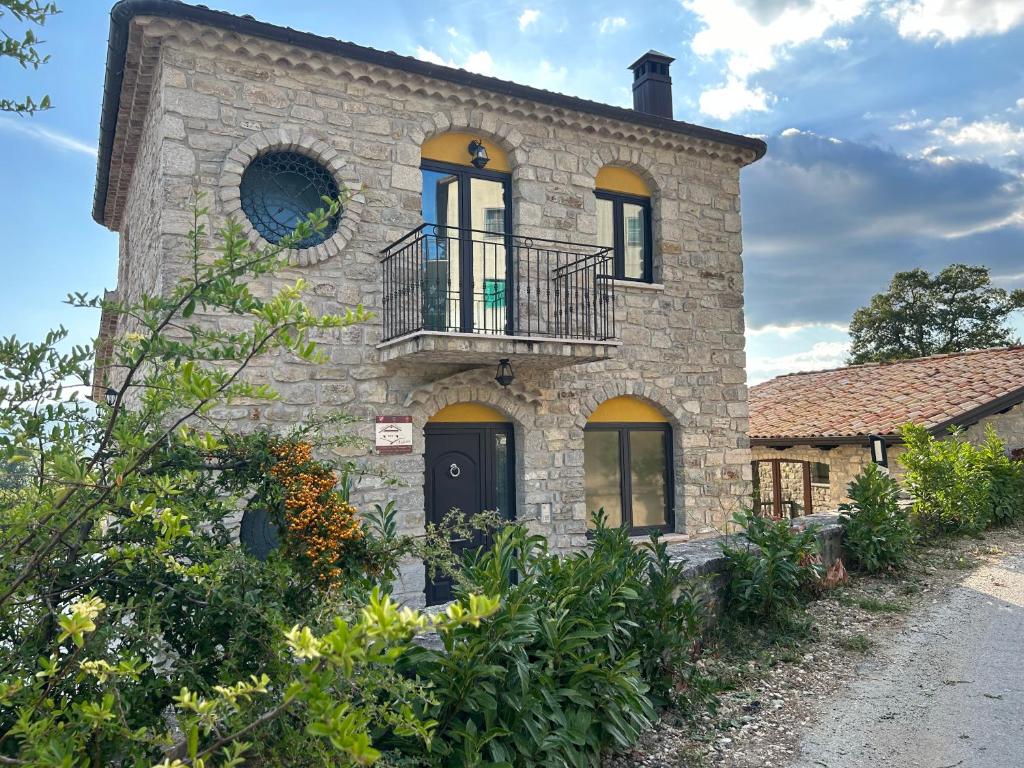 Casa de piedra antigua con balcón en una calle en Dimora Rurale Valerio, en Cercemaggiore