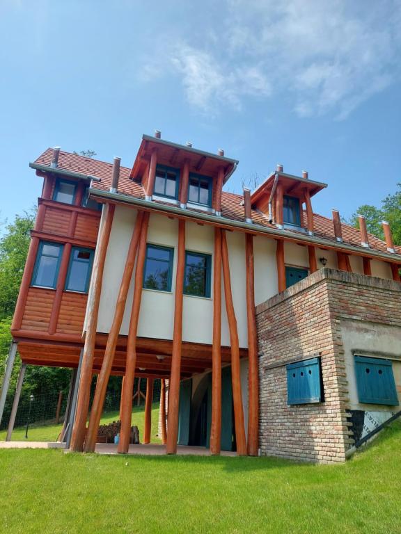 Casa grande con ventanas grandes en la parte superior. en Vendégház Petörke, en Bárdudvarnok