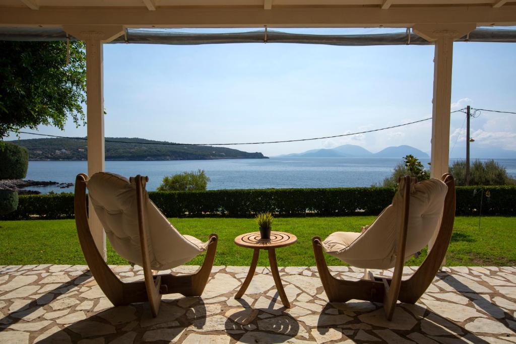 Ionian Calm Villas في فاسيليكي: كرسيين وطاولة مطلة على الماء