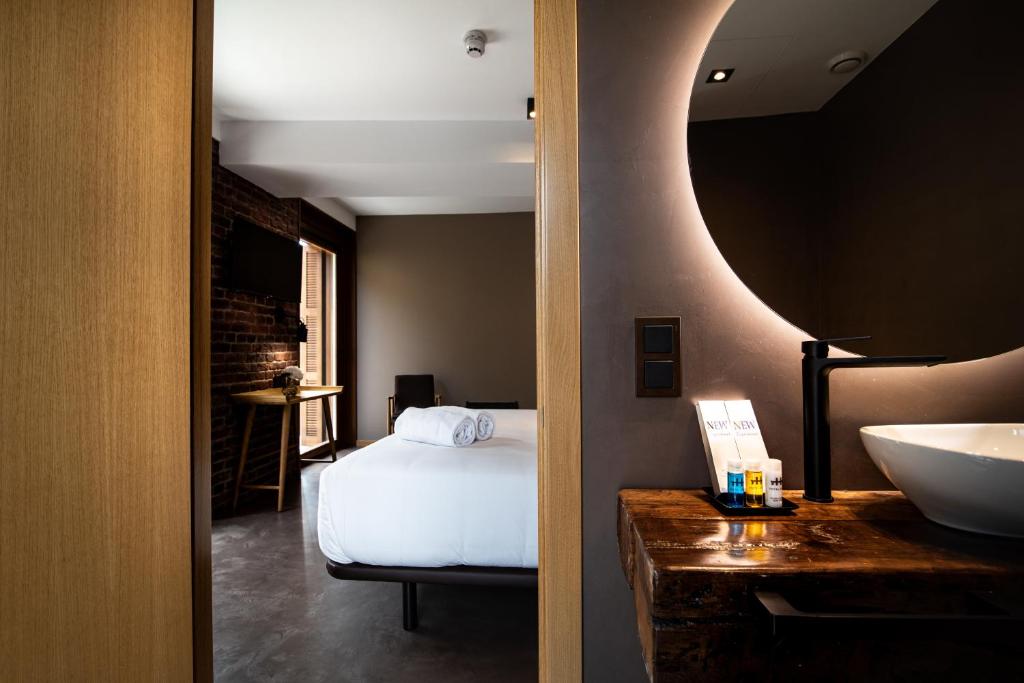 a bedroom with a bed and a sink and a mirror at Hotel Atari in Donostia-San Sebastián