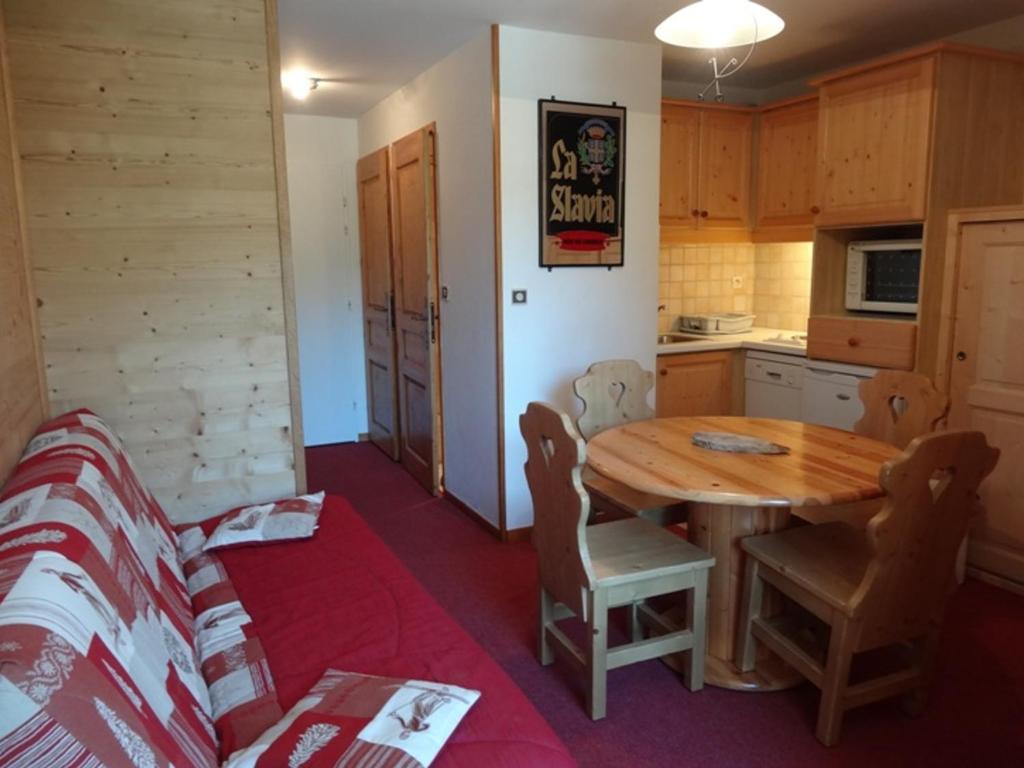 - une cuisine avec une table et des chaises en bois dans la chambre dans l'établissement Appartement Les Menuires, 2 pièces, 4 personnes - FR-1-178-29, aux Menuires