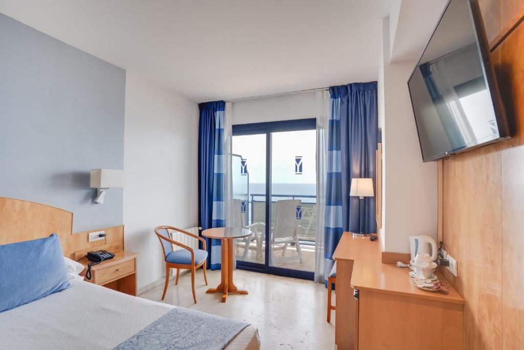 a hotel room with a bed and a table and a window at Hotel Yaramar - Adults Recommended in Fuengirola