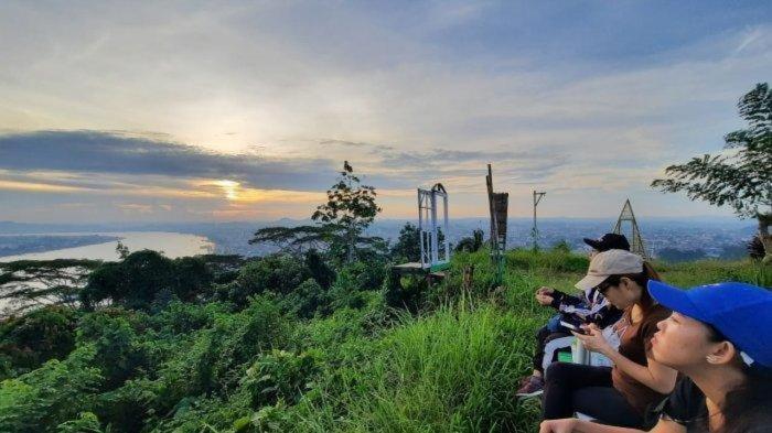 een groep mensen die bovenop een heuvel zitten bij Gunung Steling in Samarinda
