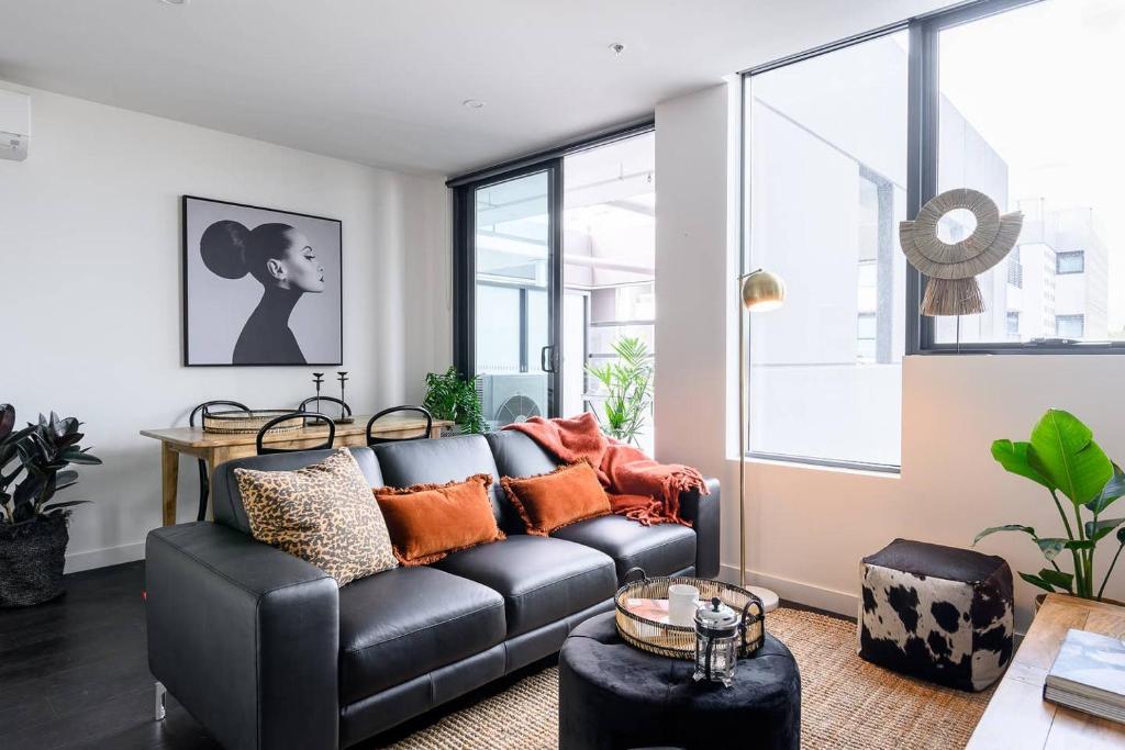 a living room with a black leather couch at Luxury Living, Richmond in Melbourne