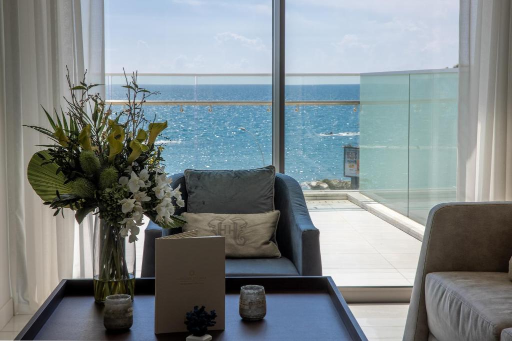 a living room with a couch and a vase of flowers on a table at Limassol Del Mar in Limassol