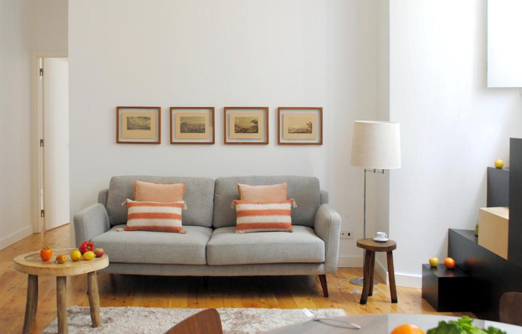 a living room with a gray couch with orange pillows at Alfama Prime Apartments by Homing in Lisbon