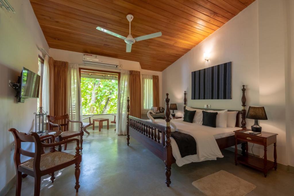 a bedroom with a bed with a wooden ceiling at Villa Birdlake in Hikkaduwa