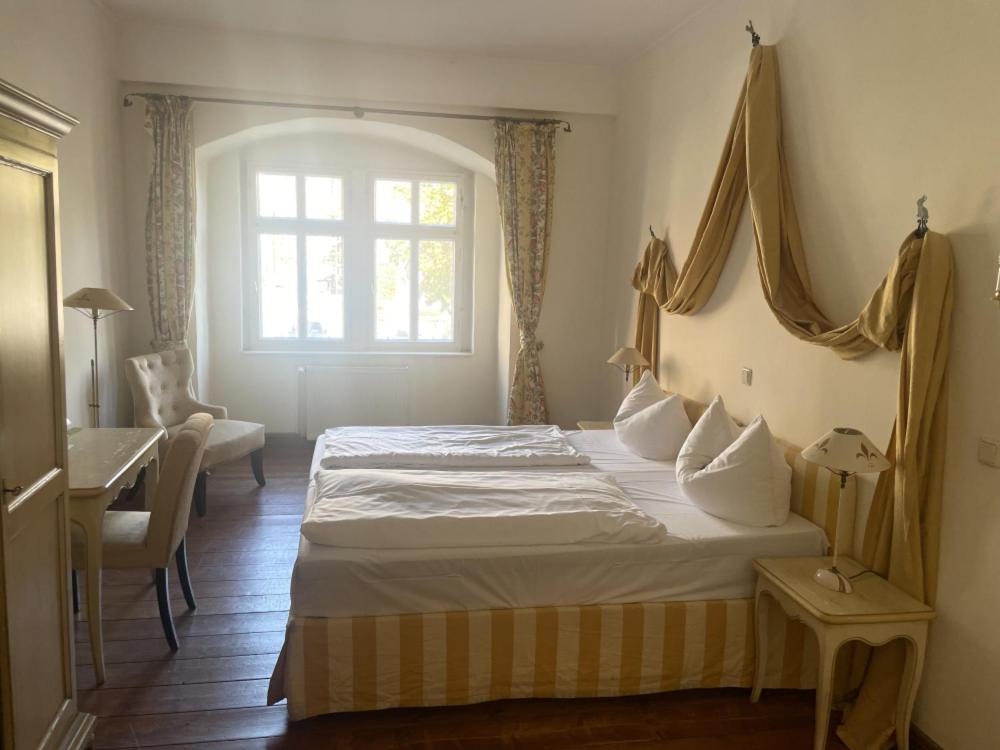 a bedroom with a large bed and a window at Hotel Adler in Rudolstadt