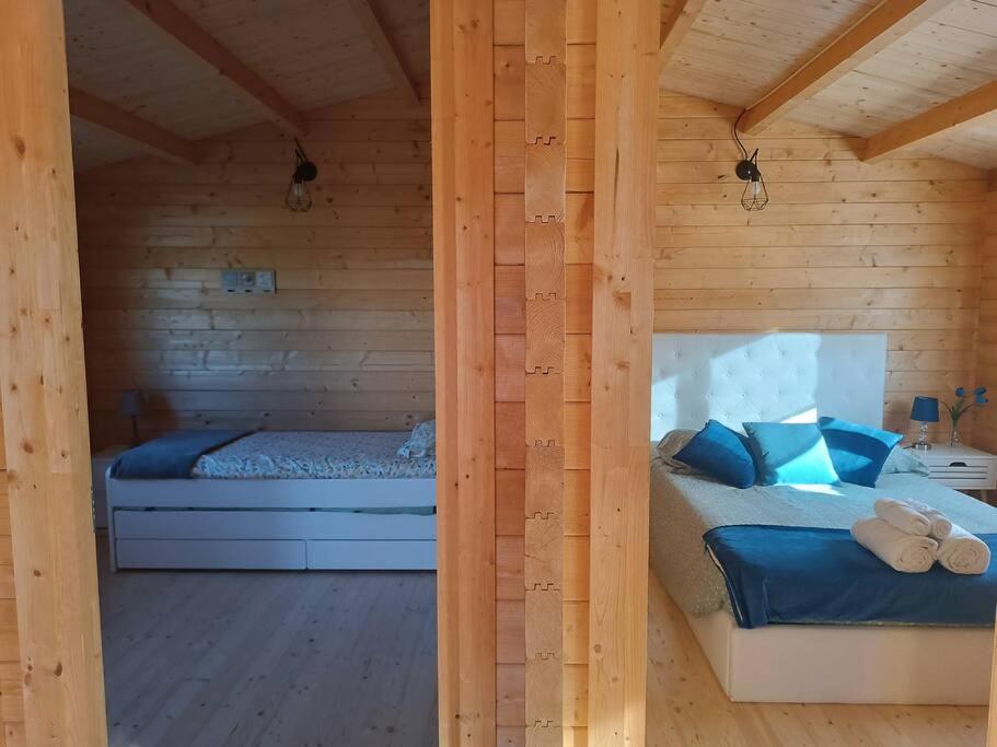 1 dormitorio con 2 camas en una cabaña de madera en Casa da Ria en Gafanha da Boa Hora