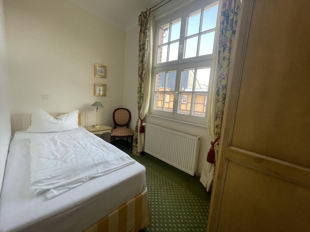 a bedroom with a bed and a window at Hotel Adler in Rudolstadt