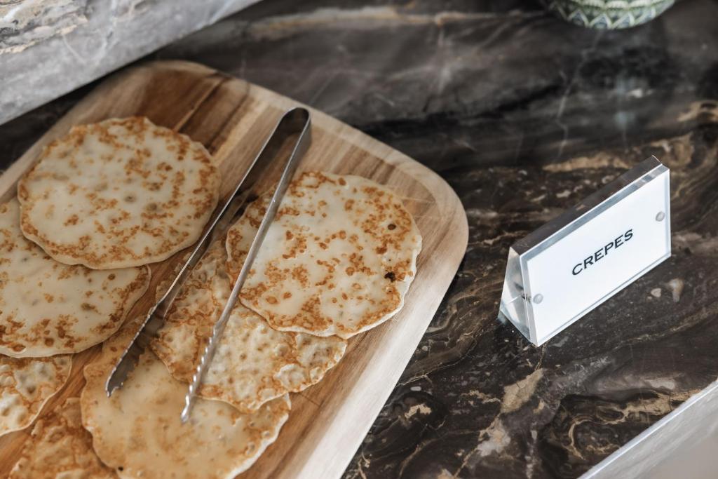 a table with a plate of pancakes and a knife at Limassol Del Mar in Limassol