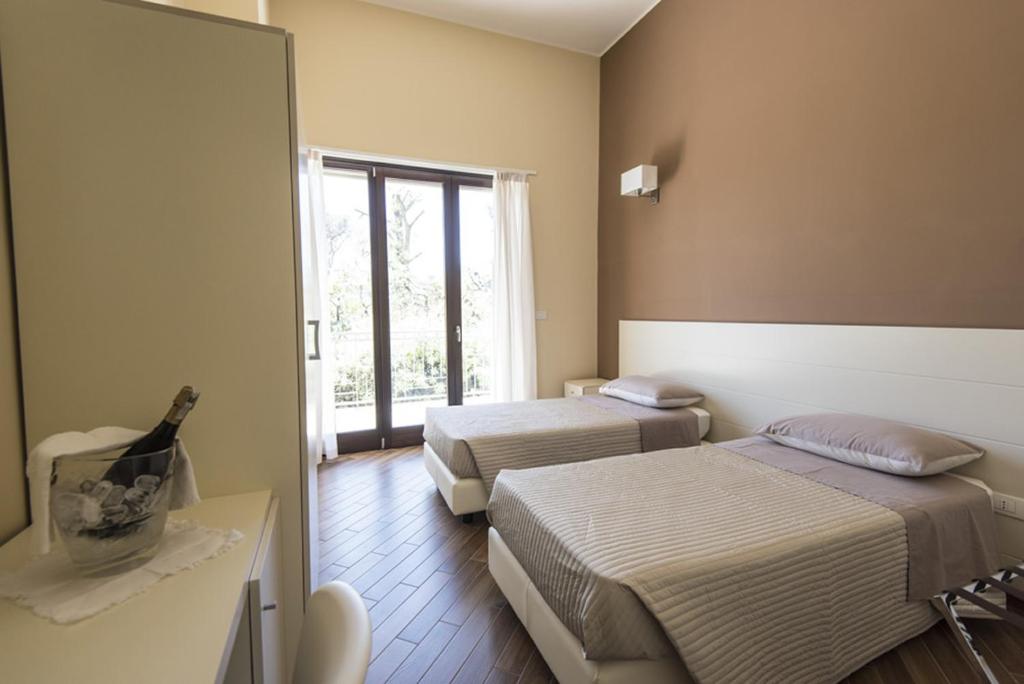 Habitación de hotel con 2 camas y ventana en Golden House, en Mesagne