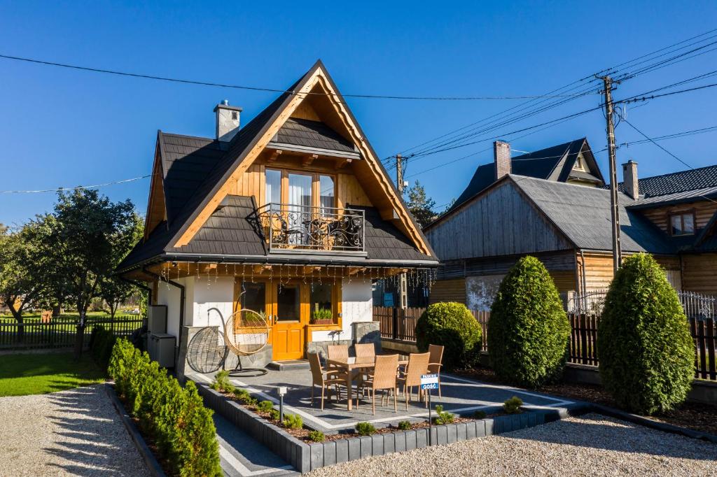 a house with a table and chairs in front of it at TatryTop Domek Białka in Białka Tatrzańska