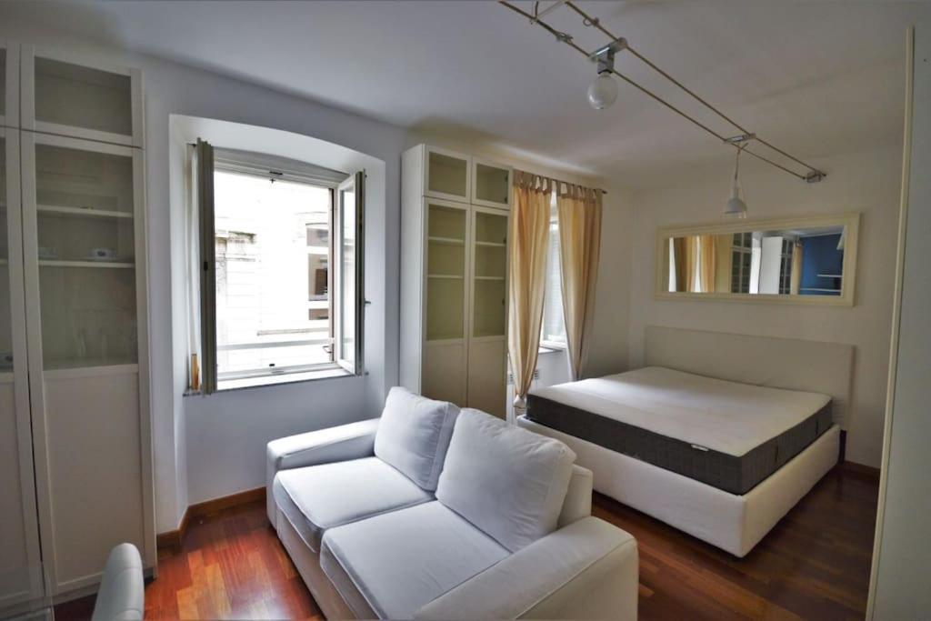 ein Schlafzimmer mit einem Bett, einem Sofa und einem Fenster in der Unterkunft Appartamento in viale in Triest