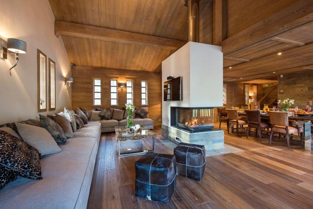 een woonkamer met een bank en een open haard bij Chalet Ambre in Tignes
