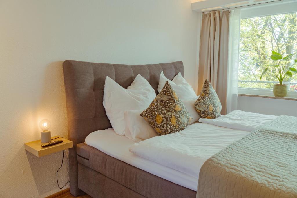 1 dormitorio con cama con almohadas y ventana en Studio Apartment mit Parkplatz en Oberesslingen