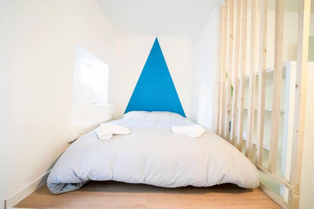 1 cama con cabecero de punta azul en una habitación en Studio - centre historique, en Agde