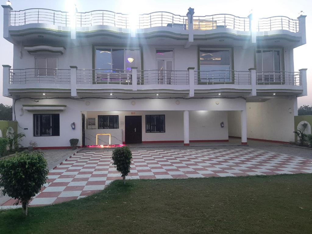 a large white building with a balcony on top at Hotel Vaidehi in Varanasi