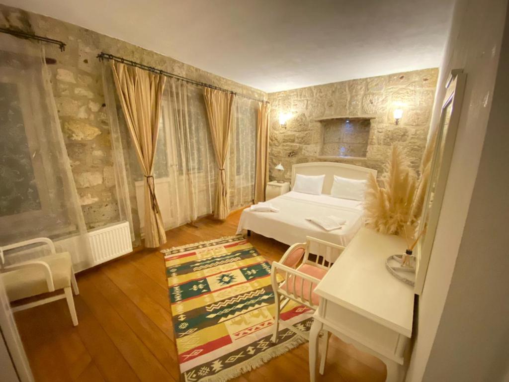 een slaapkamer met een bed en een tafel en stoelen bij MaSaLa Otel in Alacati