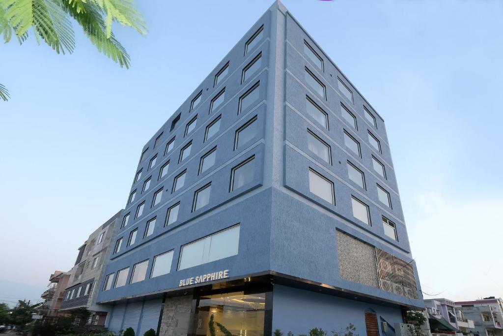 un edificio alto gris con una tienda delante en Hotel Blue Sapphire en Kota