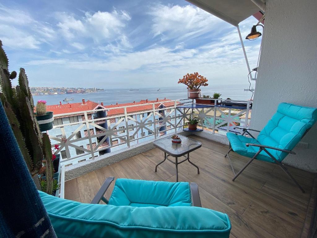 a balcony with two chairs and a table and the ocean at Moderno, iluminado y céntrico, Valparaíso in Valparaíso