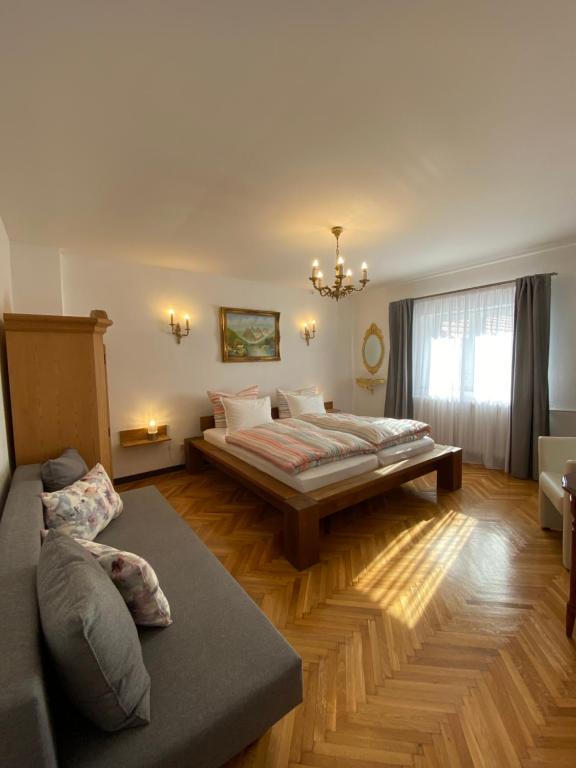 ein Wohnzimmer mit einem Bett und einem Sofa in der Unterkunft Casa Tei in Turnişor