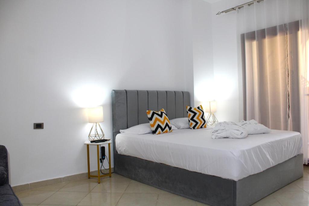a bedroom with a large bed with two pillows at Apartment inside 5* star hotel private beach with reef (FOREIGNERS ONLY) in Hurghada
