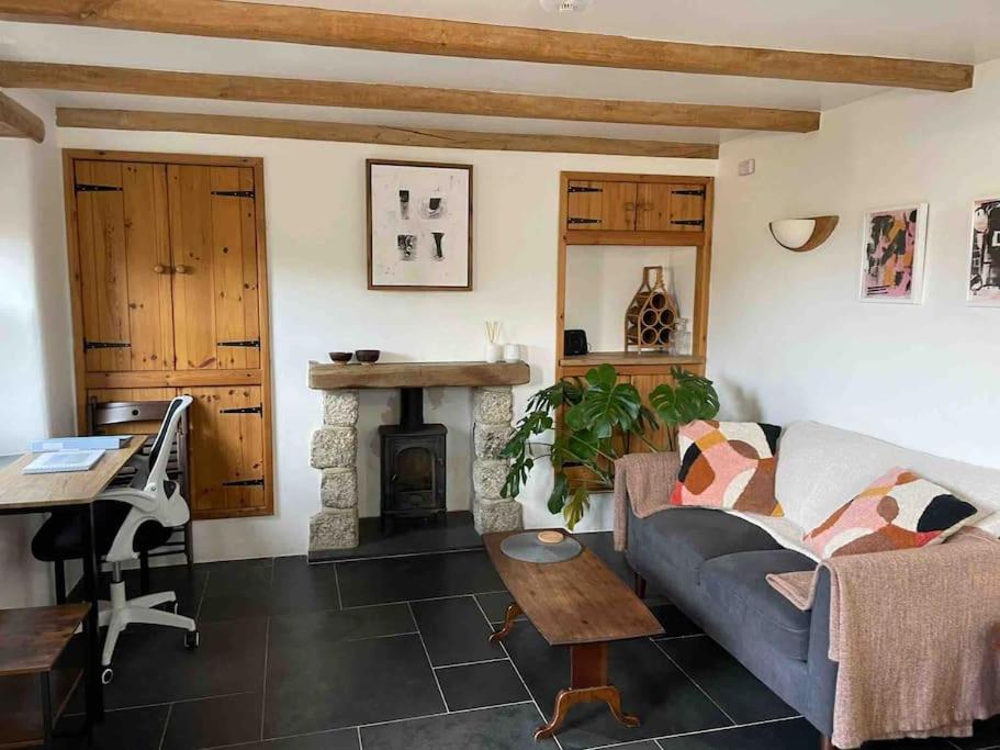 a living room with a couch and a fireplace at 9A Viaduct Cottage - the cosiest bolthole in the SW! in Hayle