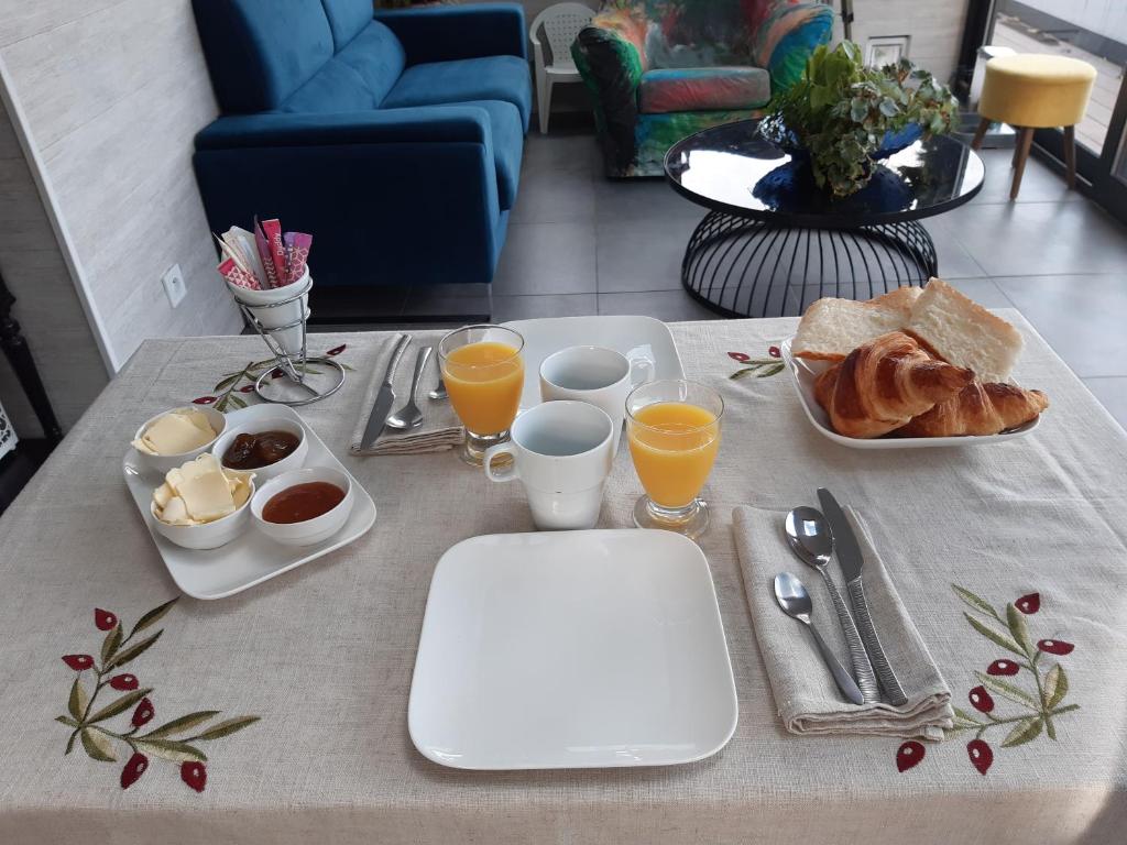 a table with breakfast foods and glasses of orange juice at LA TOULOTTE chez Claire et Christian in Sancy-lès-Provins