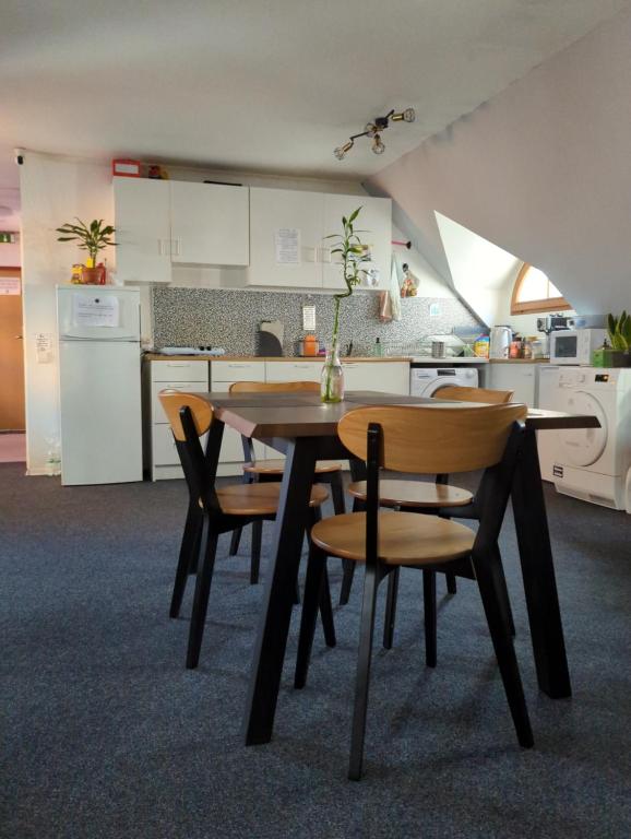 a kitchen with a wooden table and chairs at Hostel John Galt in Brno